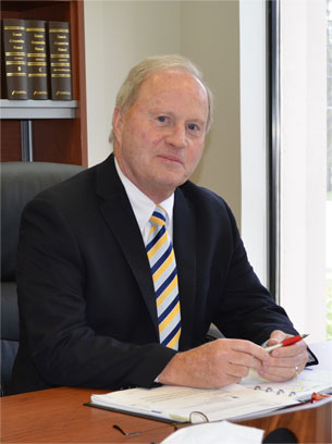 Brian Forbes sits at a desk.