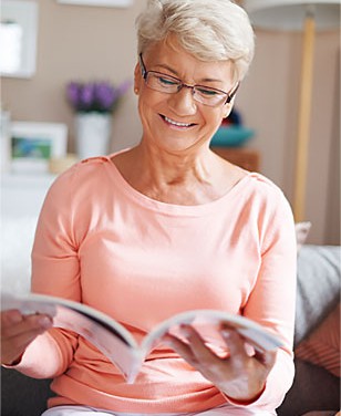 An elderly woman reading an informational booklet.