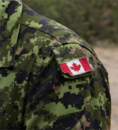 Gros plan d'un uniforme des Forces canadiennes avec un drapeau canadien en velcro sur l'épaule.